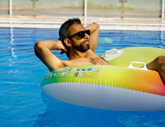 Adeel Chowdhry floating on a tube in pool relaxing