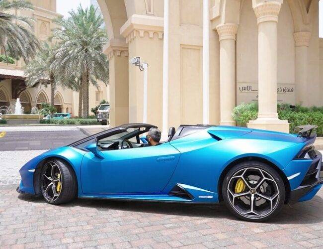 Adeel Chowdhry pulling up to a luxurious Dubai hotel in his blue Lamboghini
