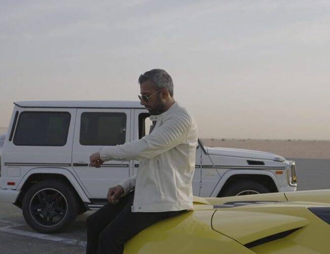 Adeel Chowdhry sitting on his yellow Lambo and his G-Wagon in background